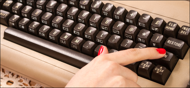 Una mujer está escribiendo en un teclado antiguo.