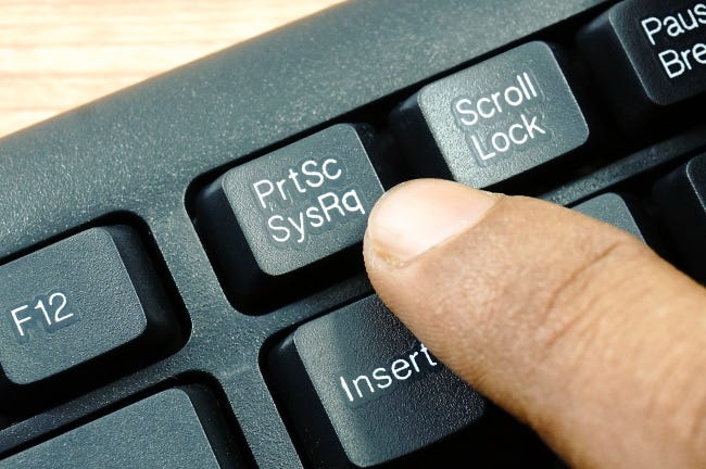 El dedo presiona la tecla PrtSc en la fila superior del teclado de la PC.